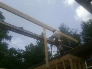 Carpenter setting a ridge beam over a new addition frame — Ice Dam Removal by Roofing Brothers in San Leandro