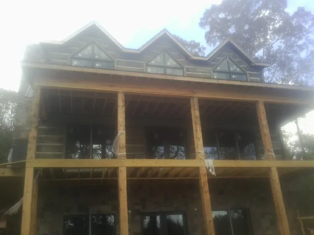 Dormers and porch framing on a large log home under construction — Roof Coating work by our crew in San Leandro