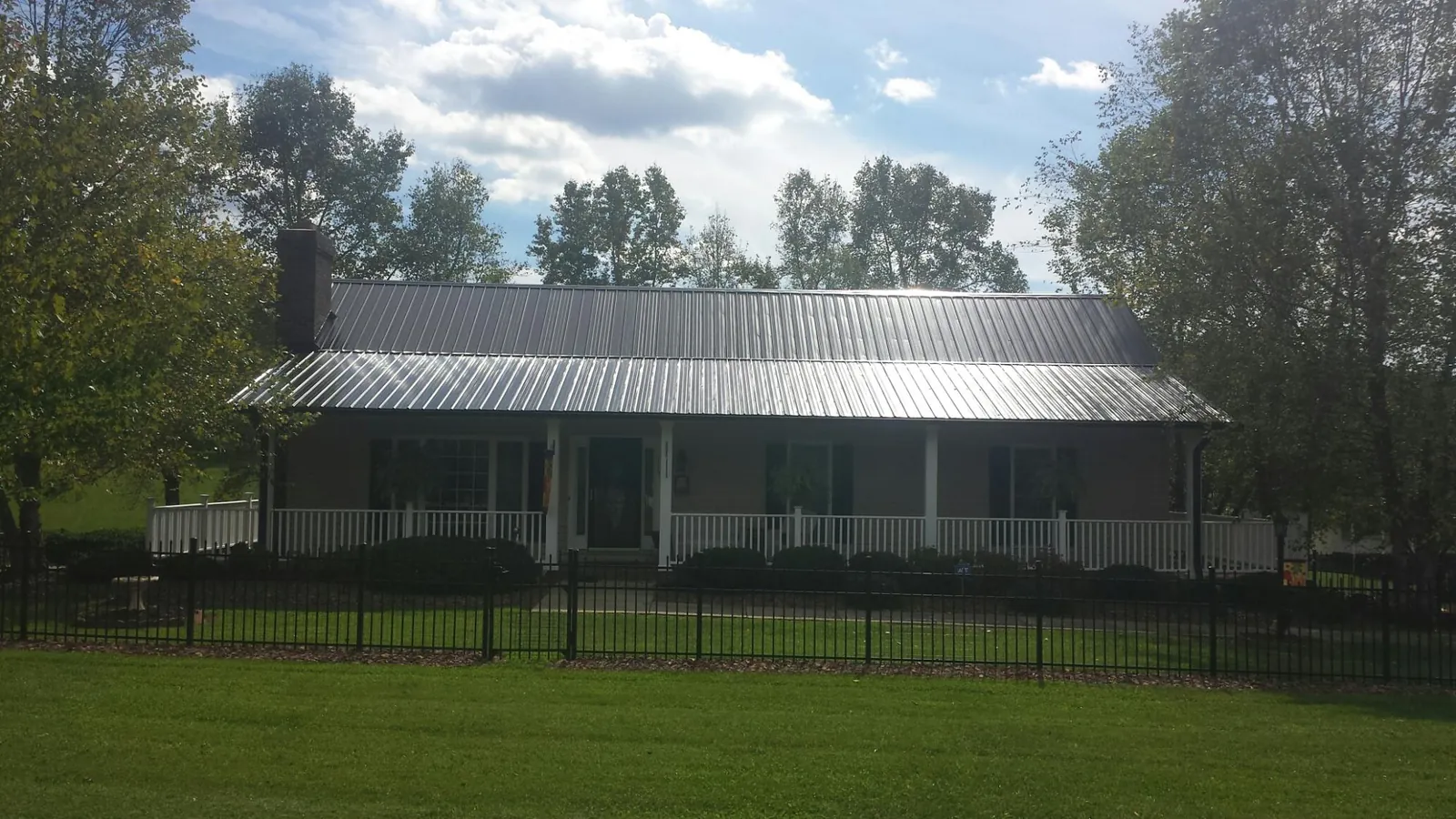 Gray metal roof on a brick ranch with a full width front porch — Gutter Guard Installation work by our crew in San Leandro
